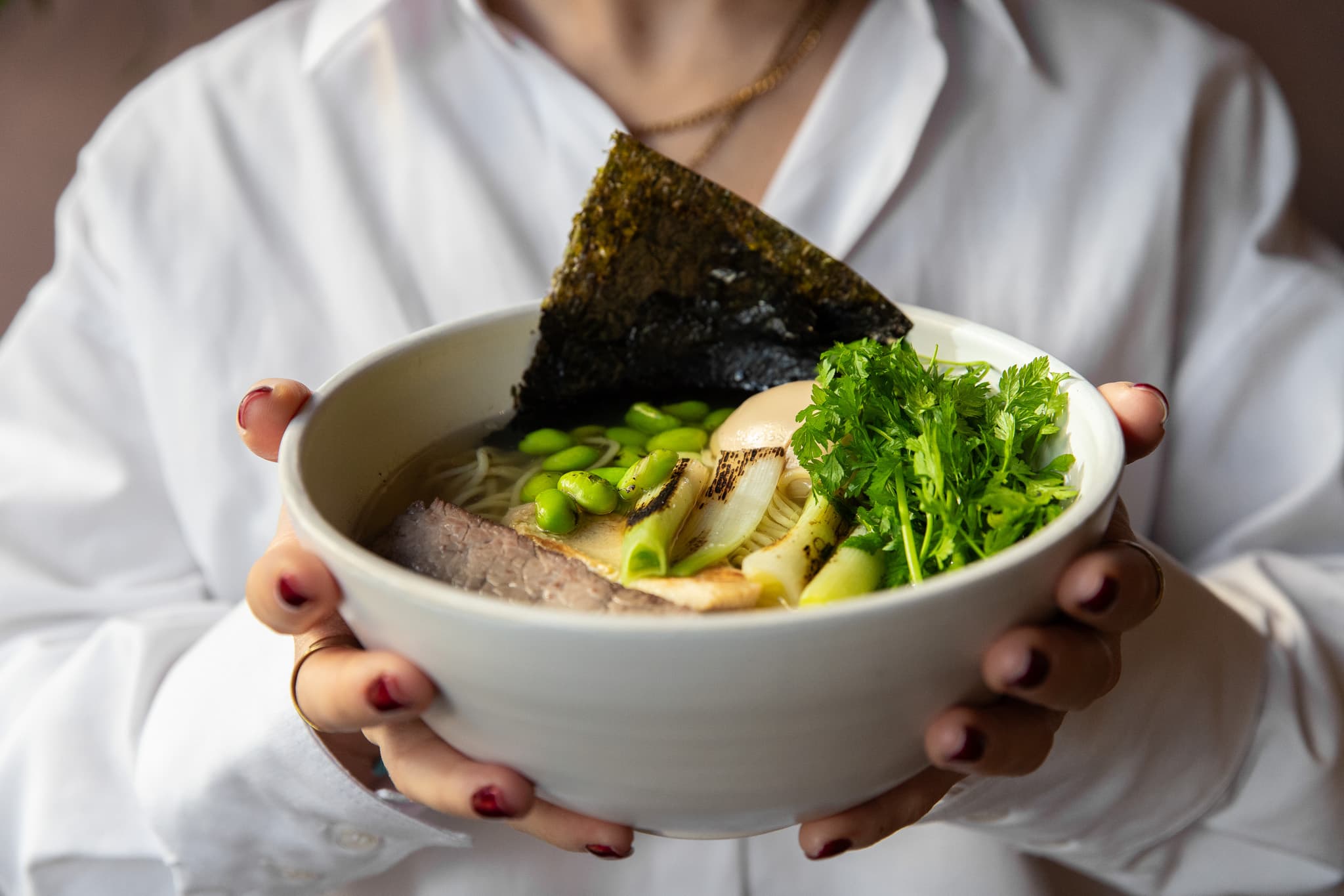 A guest holding a bowl of ramen