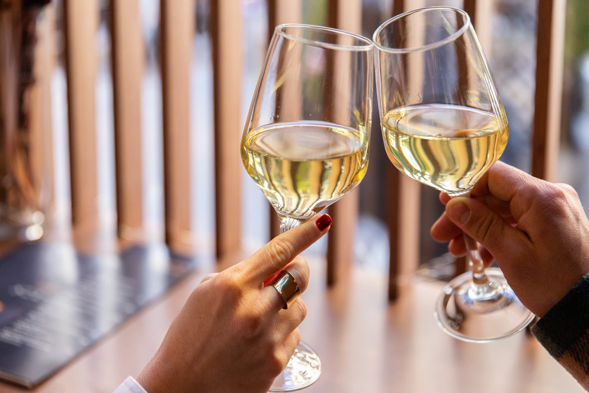 Two glasses of white wine touching in a toast
