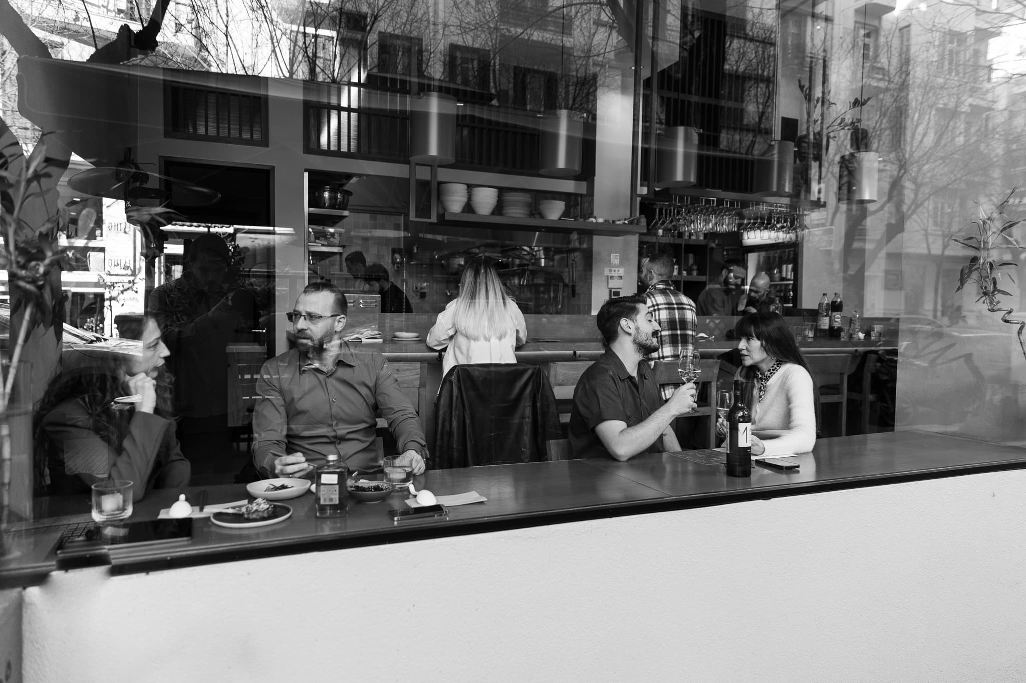 Guests at the counter of Ramen Tales, seen through the window
